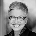 Profilbild von Heike Merten. Sie hat kurze helle Haare und trägt eine dunkle Brille. Sie lächelt in die Kamera.