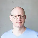 Profilbild von Marco Pöhler. Er trägt eine Brille und hat kurze Haare. Er schaut mit geschlossenem Mund in die Kamera.