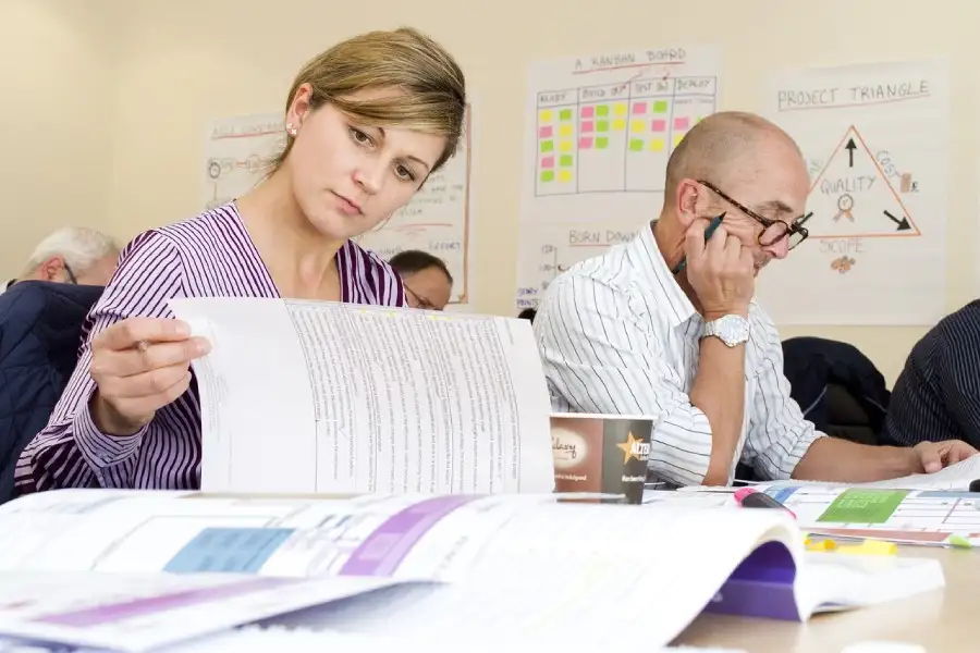 Product Leader mit UX-Skills bei der Arbeit. Man sieht eine Frau und einen Amann bei der konzentrierten Arbeit über Dokumenten