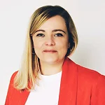 Profilbild von Maria Rechcygier. Sie trägt einen roten Blazer über einem weißen Shirt. Die langen blonden Haare liegen seitlich über der Schulter. Sie blickt nach vorne und lächelt in die Kamera.